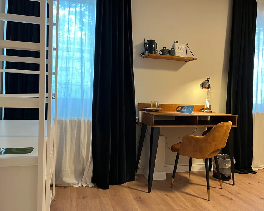 Schreibtisch am Fenster mit Vorhängen